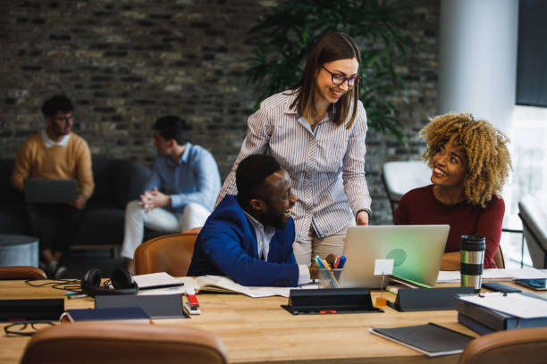 istock Group of colleagues hanging out while co-working in a modern office space 1390983877