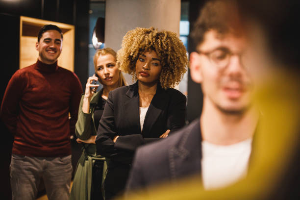Annoyed people waiting in line to be hosted by a receptionist at front desk stock photo