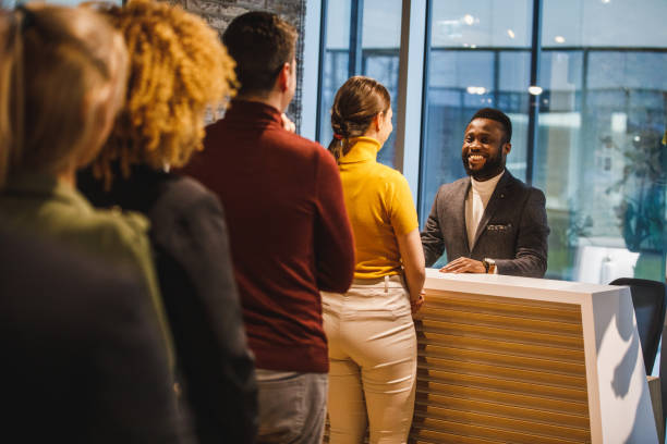 Group of people standing in line behind reception in office space stock photo