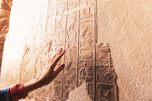 Un egiptólogo o arqueólogo lee y traduce jeroglíficos egipcios tallados en piedra photo