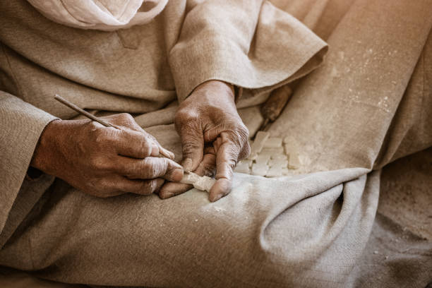 Close-up of artisan hands carving a stone souvenir or amulet for sale to tourists. Craft and handmade concept. Close-up of artisan hands carving a stone souvenir or amulet for sale to tourists. Craft and handmade concept. calcite stock pictures, royalty-free photos & images