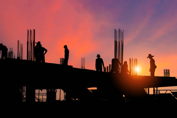 istock Silhouette of Foreman worker team at construction site with blurred sunset sky background 1390989572