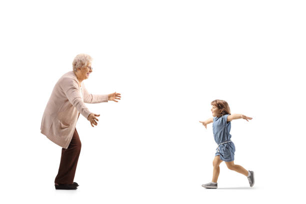 scatto a profilo completo di un bambino che corre verso la nonna con le braccia spalancate - grandmother child grandparent isolated foto e immagini stock