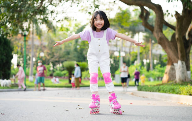 Caucasian girl riding in roller skates on road in park on summer day