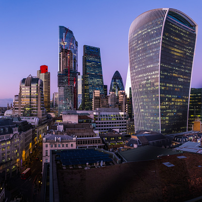 Rascacielos futuristas de la ciudad de Londres que brillan al atardecer sobre el distrito financiero photo