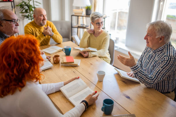 istock Senior Caucasian friends discuss the reference book, during book reading meeting 1390992949
