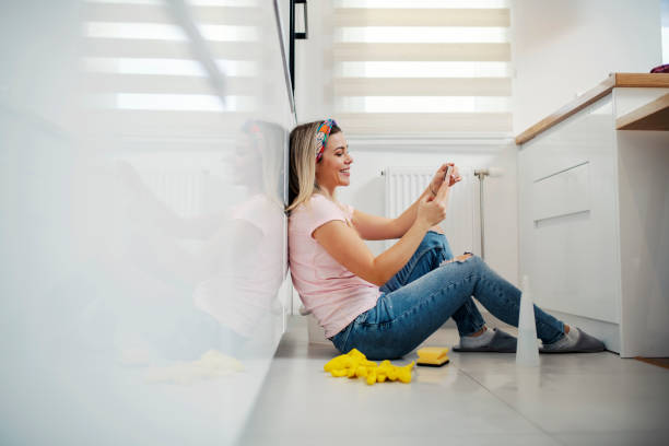 istock A woman taking a break from chores and using phone in kitchen. 1390993233
