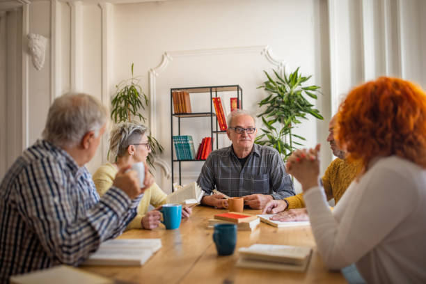 istock Senior people reading and discuss the reference book, during book reading meeting 1390993322