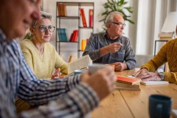 istock Senior friends reading and discuss the reference book, during book reading meeting 1390993454