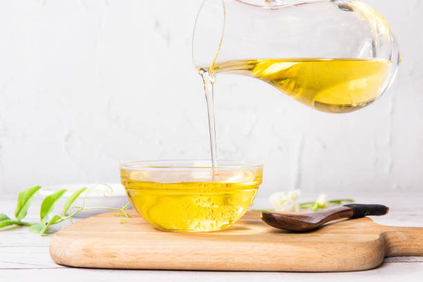 istock Pouring cooking oil into glass bowl on table 1390993718
