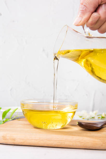 istock Pouring cooking oil into glass bowl on table 1390993719