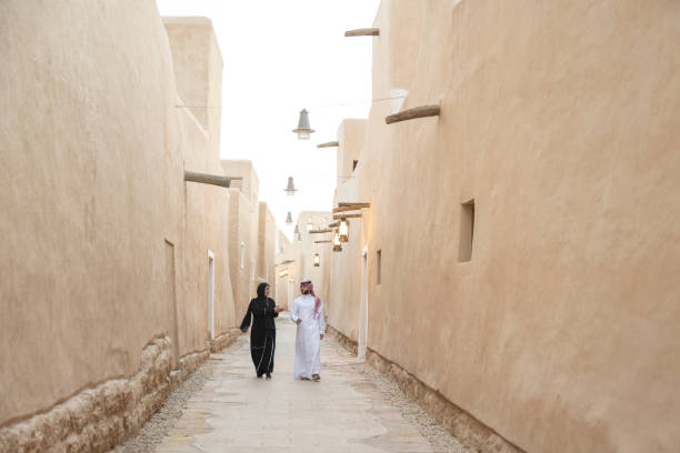 istock Saudi man and woman walking amidst restored ruins 1390994401