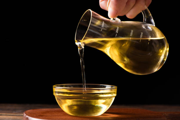 istock Pouring cooking oil into glass bowl on table 1390994711