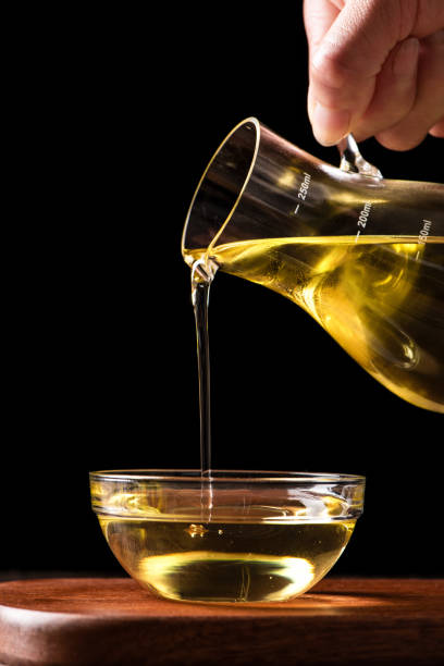 istock Pouring cooking oil into glass bowl on table 1390994715