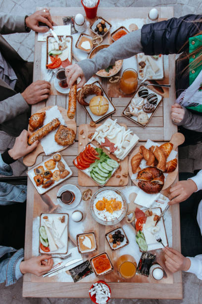 istock people eating breakfast, people eating, Turkish Breakfast,  Sunday big breakfast or brunch with white cheese and egg, Turkish spread breakfast served in the restaurant, menemen, orange juices 1390998636