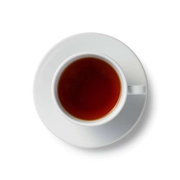 fermez une tasse complète de thé rouge noir sur une soucoupe blanche - color image copy space high angle view isolated photos et images de collection