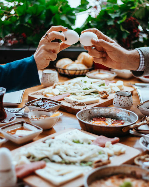 knocking eggs together, two people having an egg contest, cracking eggs by hitting each other, eating eggs for breakfast