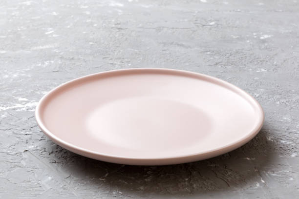 istock Perspective view of empty pink plate on cement background. Empty space for your design 1390999778