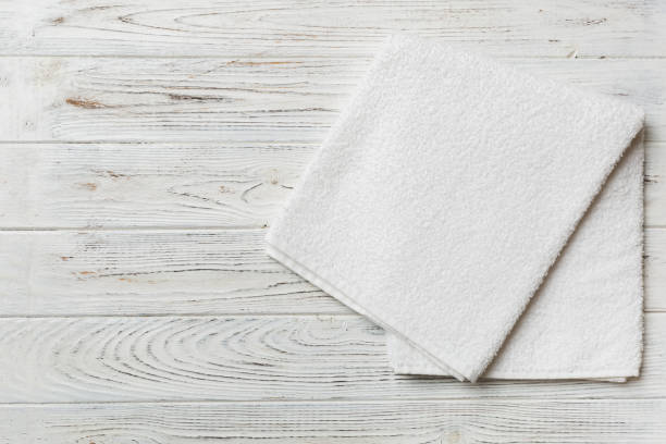 istock Top view of white towels with copy space on colored background 1390999798