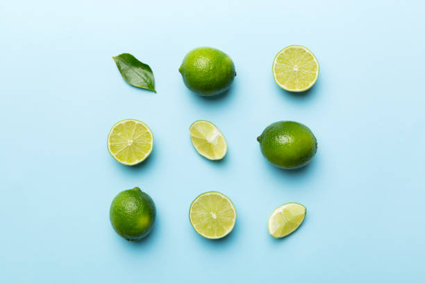 istock Lime fruits with green leaf and cut in half slice isolated on white background. Top view. Flat lay with copy space 1390999857
