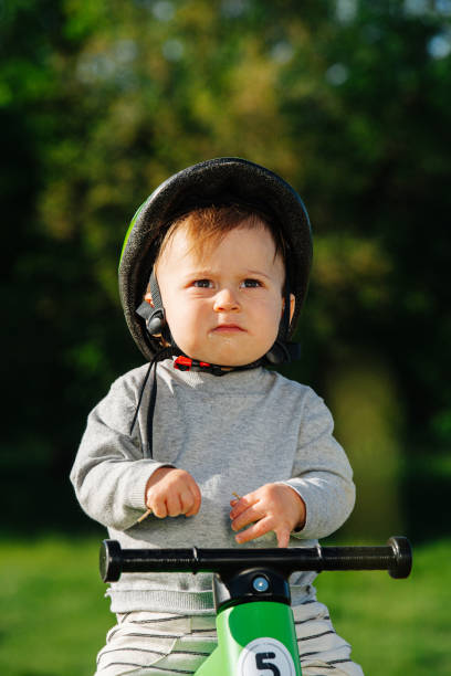 istock Grumpy little kid sitting on a three-wheel foot bike 1391000219