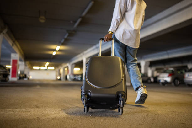 istock At the underground parking lot, unrecognizable woman Black ethnicity pulling suitcase 1391001766