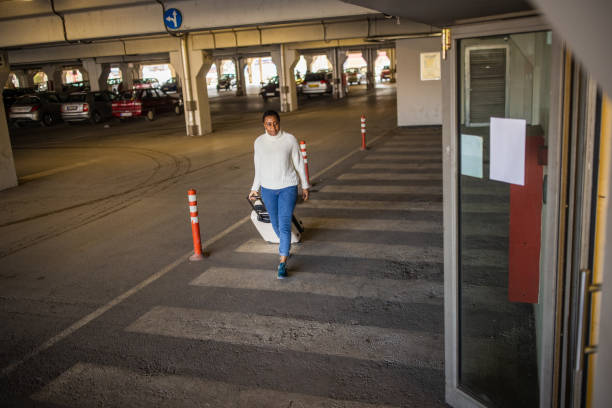 istock At the underground parking lot, woman Black ethnicity pulling suitcase 1391002373