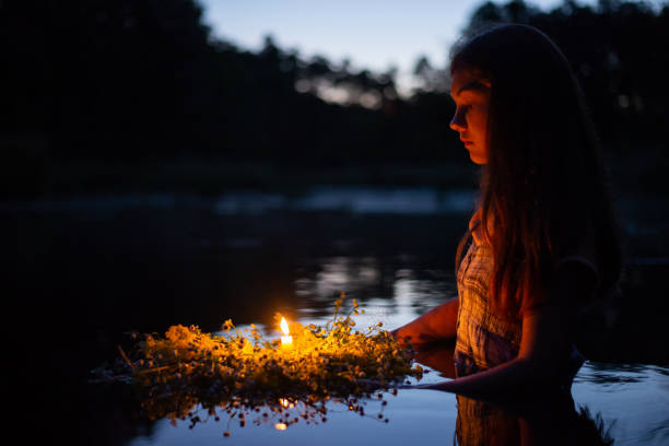 retrato de una niña pequeña en el río a altas horas de la noche, puso la corona a flotar con una vela - solsticio de verano fotografías e imágenes de stock