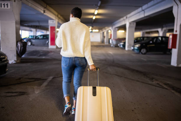 istock At the underground parking lot, unrecognizable woman Black ethnicity pulling suitcase 1391002898