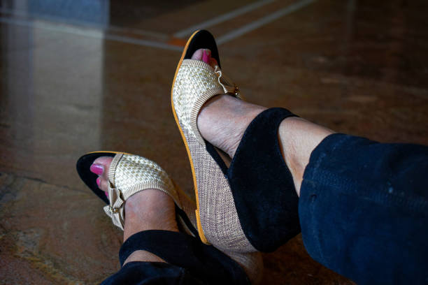 Stock photo of women feet, wearing black and cream color fancy high hell sandal and posing for photo. Picture captured under natural light at Bangalore, Karnataka, India. focus on object. stock photo