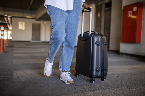 istock At the underground parking lot, unrecognizable woman Black ethnicity pulling suitcase 1391005067