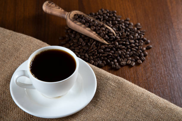 istock White cup of filter coffee with coffee beans on wooden background 1391005710