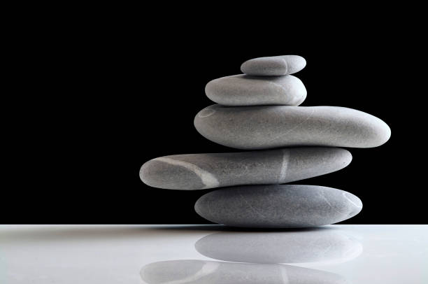 istock stack of five gray stones balancing on white plane and black background 1391006661