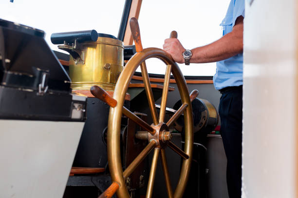 Close view into captain's cabins, navigation equipment and captain's hand on rudder during cruising