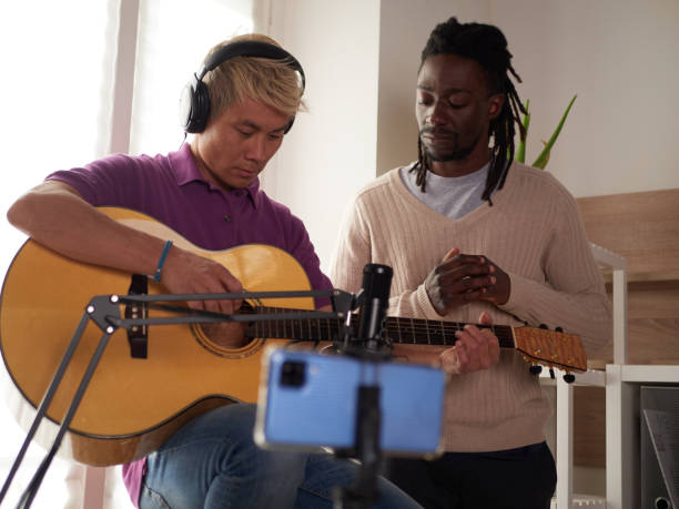 istock A personal afroamerican tutor explains to his asian student how to play studied chord correctly. Musical education at home 1391014743