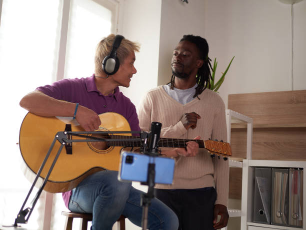 istock A personal afroamerican tutor explains to his asian student how to play studied chord correctly. Musical education at home 1391014786