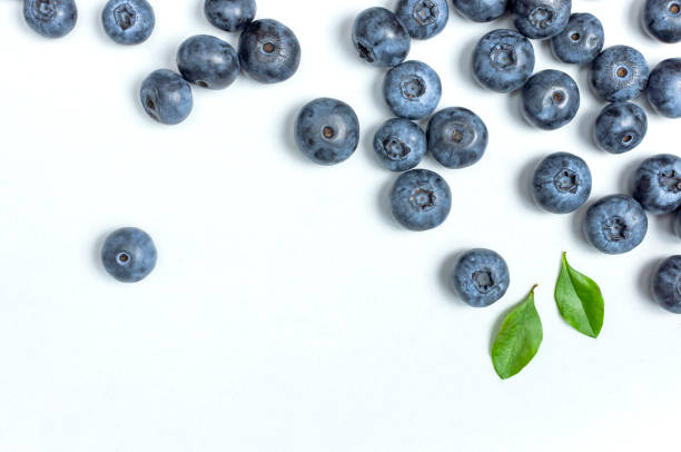 fondo de arándanos. arándanos frescos y jugosos con hojas verdes sobre fondo blanco. espacio de copia de vista superior plana. bayas saludables, alimentos orgánicos, antioxidantes, vitaminas, alimentos azules. marco de arándanos - blueberry fotografías e imágenes de stock