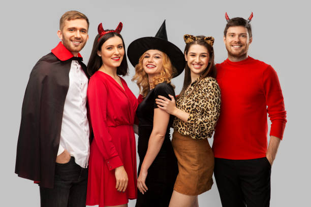 istock happy friends in halloween costumes over grey 1391015607