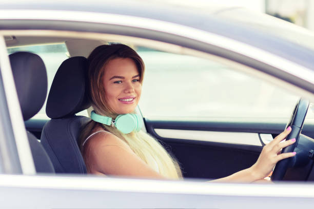 portrait of teenage girl in her first car - car dealership audio imagens e fotografias de stock