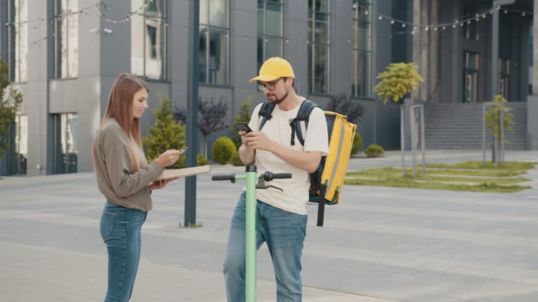 Pizza Delivery or small box. Fast Food Delivery, Cashless Payment credit card. Female consumer paying using debit card. Delivery of a small package from the online store