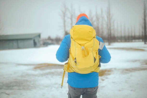 uma vista da parte de trás de um alpinista irreconhecível que gosta de caminhadas. isl - rear view winter blizzard nordic countries - fotografias e filmes do acervo