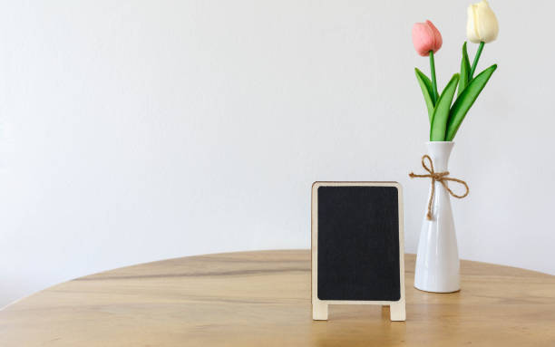 istock Blank black frame mock up picture frame  mini  tree in pot on wooden table 1391021846