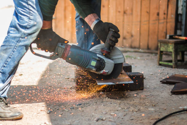 istock A gloved worker cuts a metal sheet with an angle grinder. Sparks fly from the grinding wheel. Industrial background. 1391023253