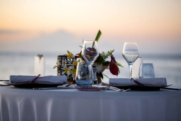 cena romantica sulla spiaggia al tramonto. - plate dinning table blue foto e immagini stock