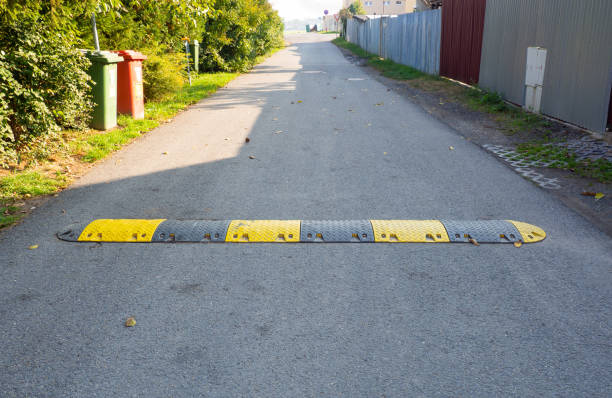 速く動く車を遅くするために道路上のスピードバンプ - yellow city speed road ストックフォトと画像