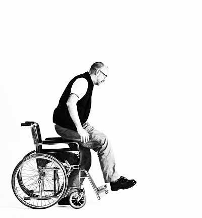 Man rising out of a wheelchair, in high-contrast black-and-white.