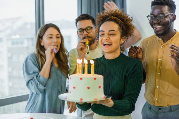 Excited young woman ready to blow out candles Four friends celebrating a birthday at home woman birthday cake stock pictures, royalty-free photos & images