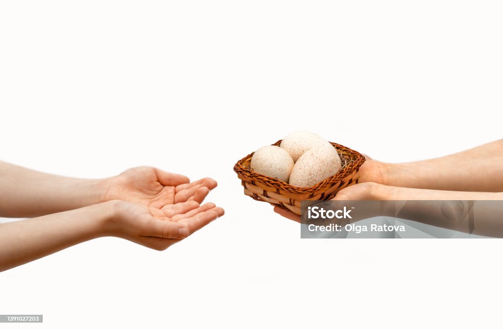 Easter holiday. The child's hands pass a basket with Easter eggs to another child. Easter holiday. The child's hands pass a basket with Easter eggs to another child. turkey eggs Basket Stock Photo
