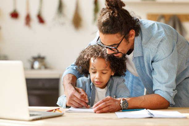 istock young ethnic father helps his   son with homework while studying online on a laptop at home 1391027962