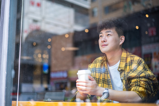 Asian handsome young man sitting in coffee shop